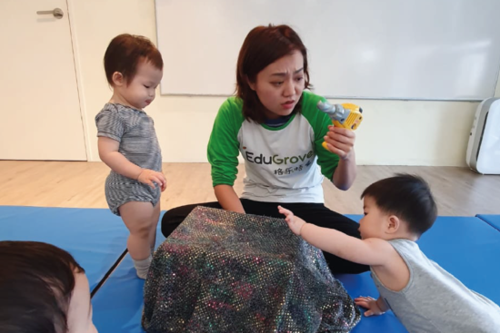 Teacher in Mandarin playgroup showing what is in the magic box